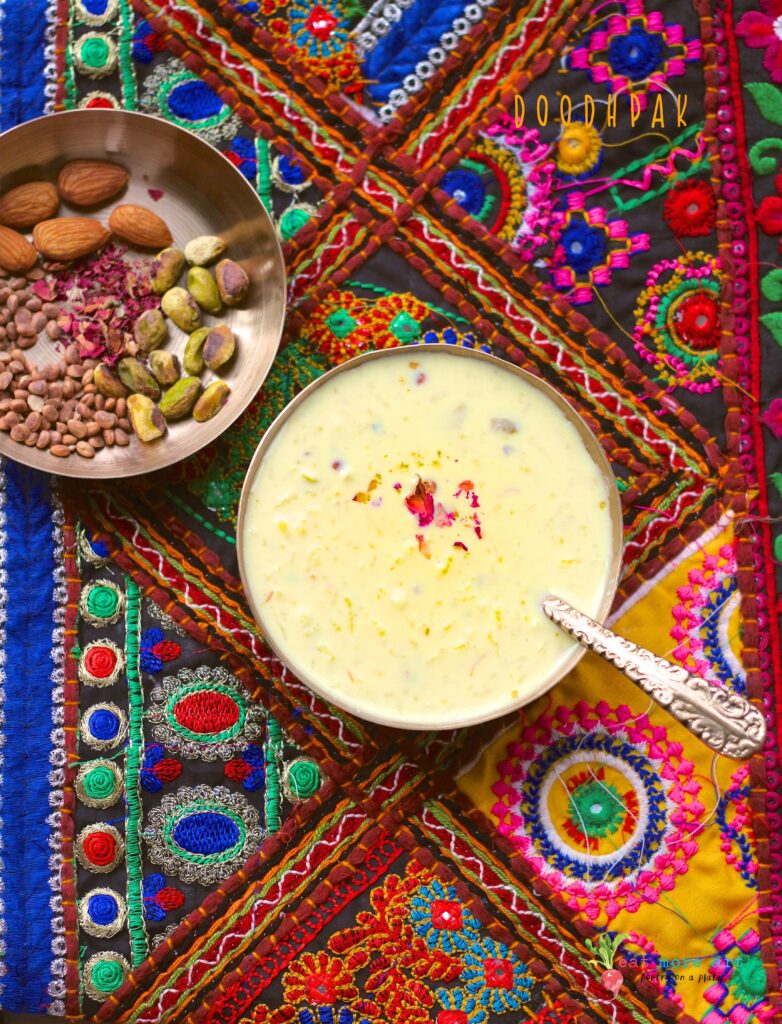 An overhead shot of a bowl of doodhpak over a colorful backdrop