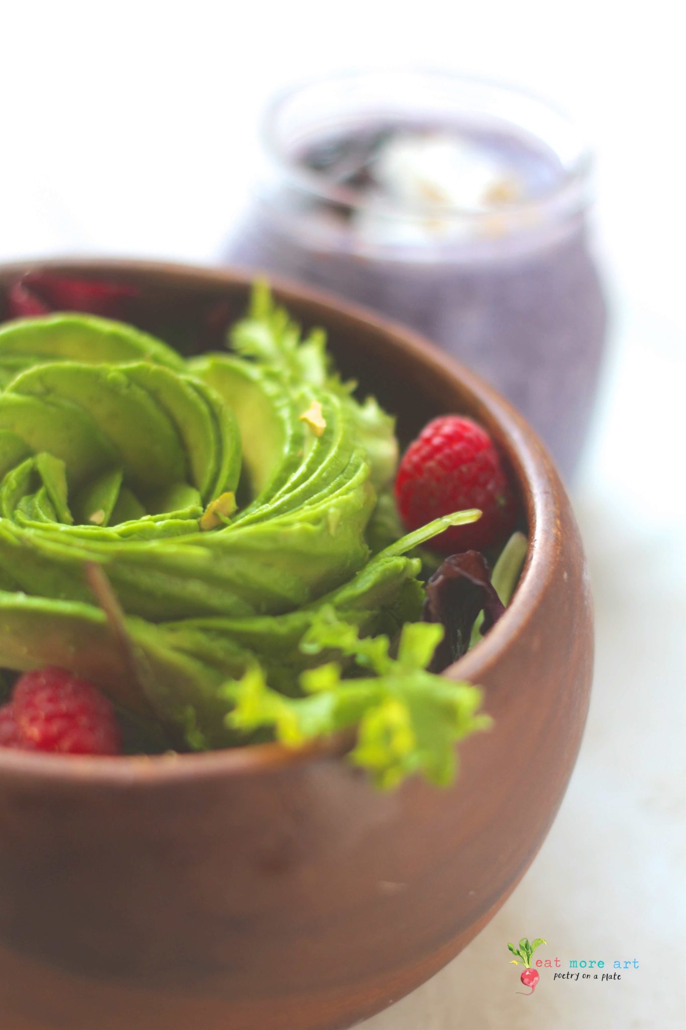 salad bowl topped with avocado rose and raspberries