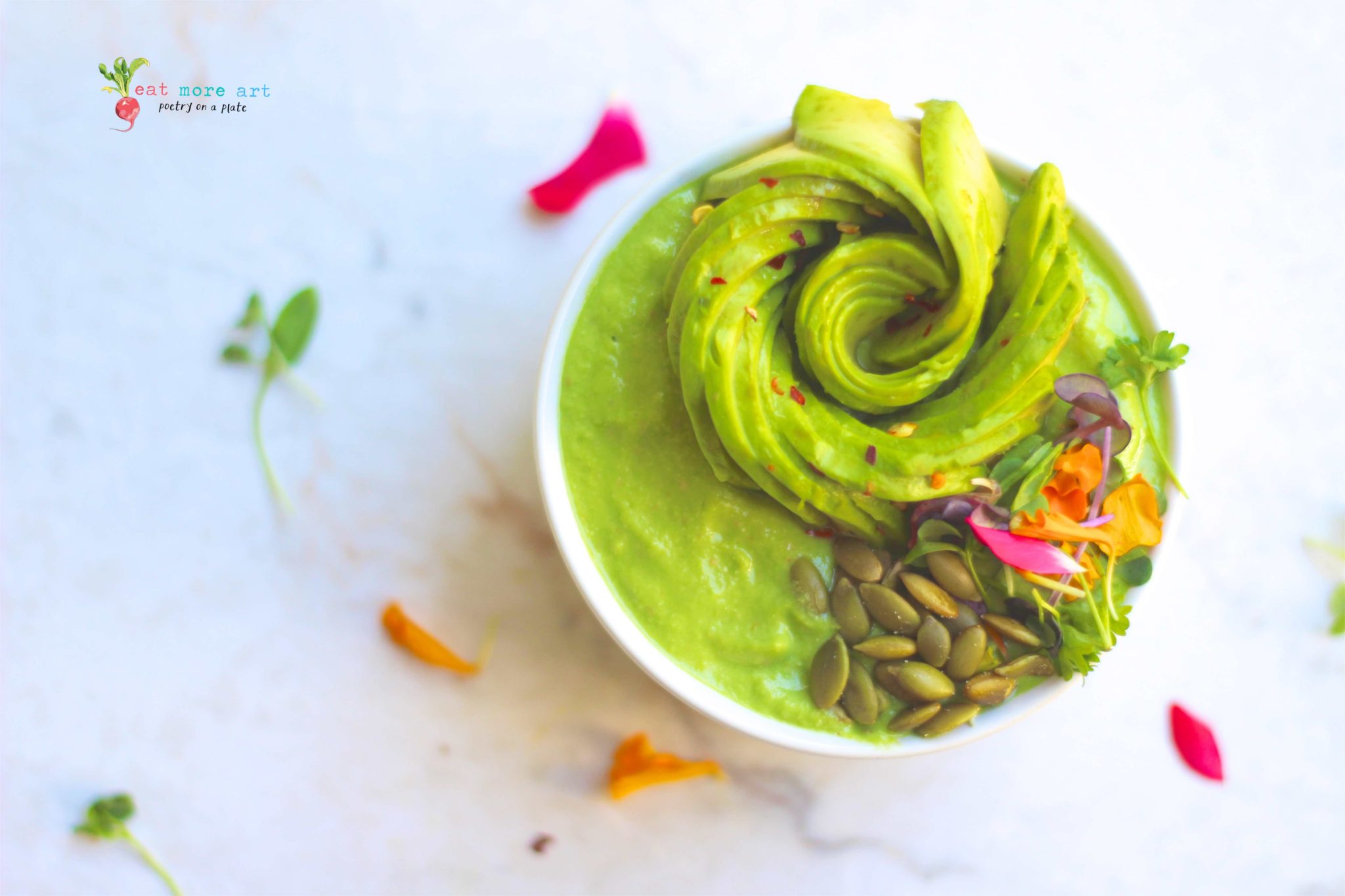green smoothie bowl topped with avocado rose and edible flowers