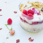 A side shot of raspberry yogurt granola parfait