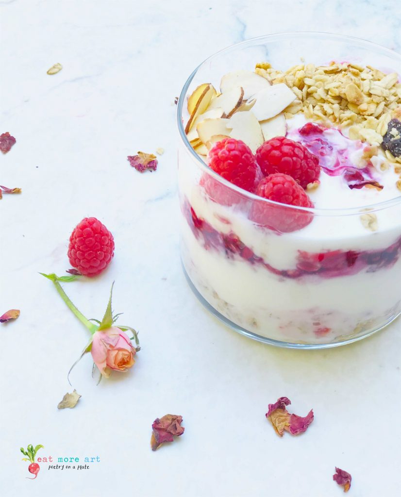 A side shot of raspberry yogurt granola parfait